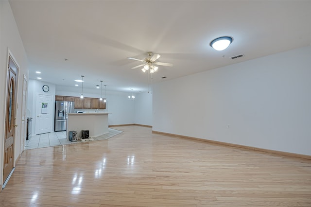 unfurnished living room featuring ceiling fan and light hardwood / wood-style flooring