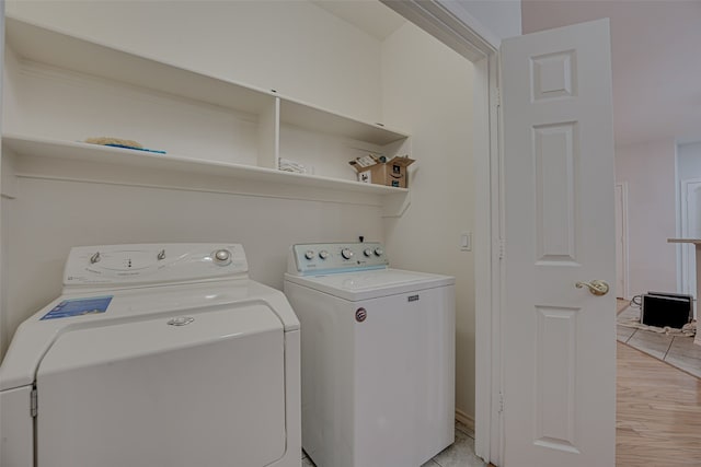 washroom with separate washer and dryer and light hardwood / wood-style floors