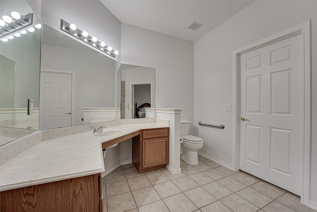 bathroom featuring vanity, toilet, and tile floors