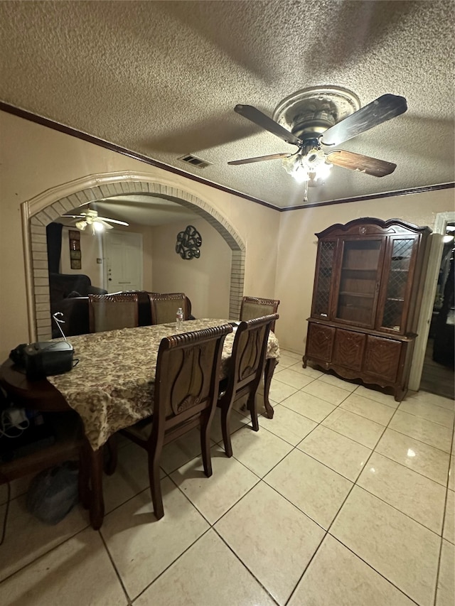 dining room with ceiling fan, a textured ceiling, and light tile flooring