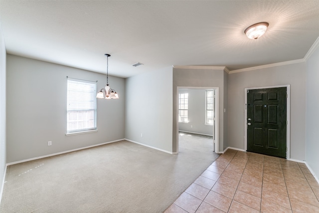 foyer with crown molding, a chandelier, light colored carpet, and a wealth of natural light