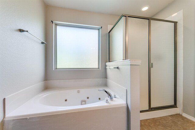 bathroom featuring a shower stall and a jetted tub