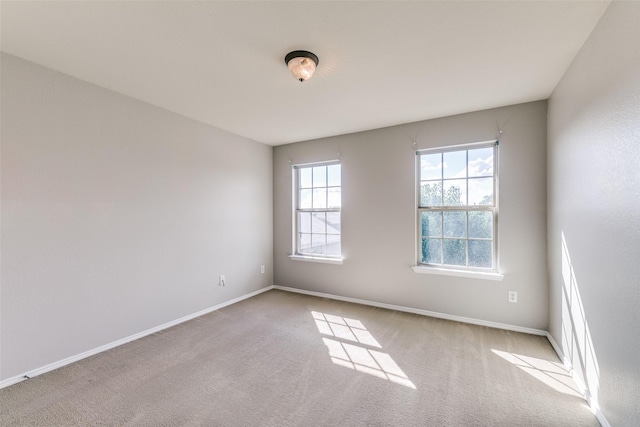 carpeted spare room featuring baseboards