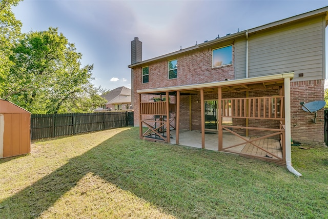 rear view of house with a storage shed, a patio area, and a yard