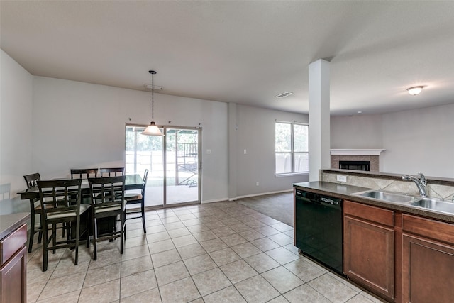 kitchen featuring dishwasher, a sink, open floor plan, a wealth of natural light, and a glass covered fireplace