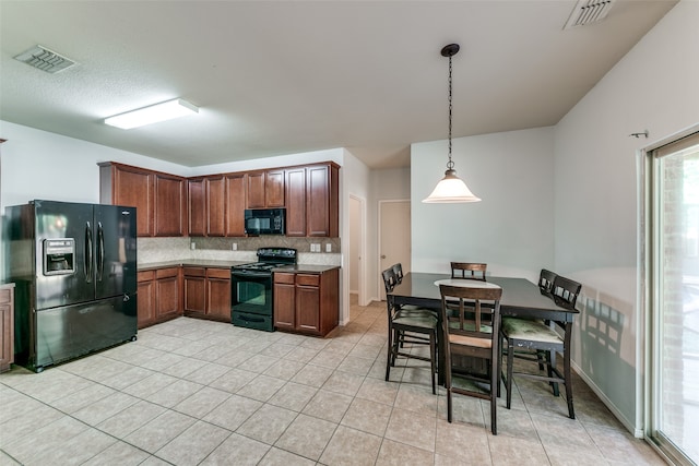 kitchen with pendant lighting, light tile patterned floors, tasteful backsplash, and black appliances