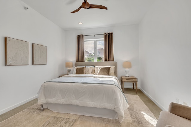 carpeted bedroom with ceiling fan and baseboards