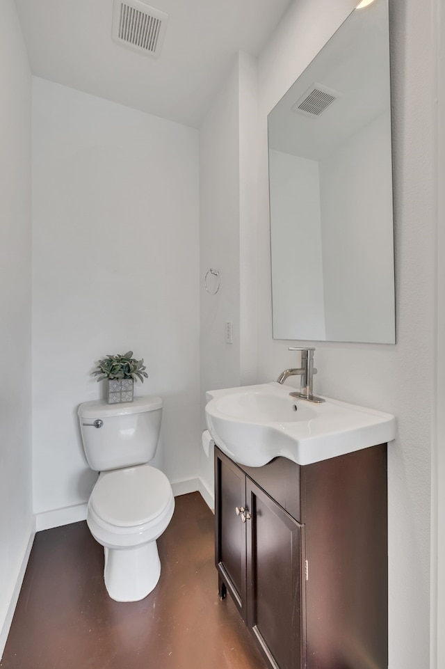 bathroom featuring visible vents, baseboards, vanity, and toilet