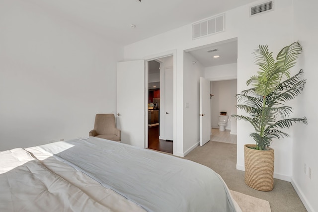 bedroom with baseboards, visible vents, and carpet