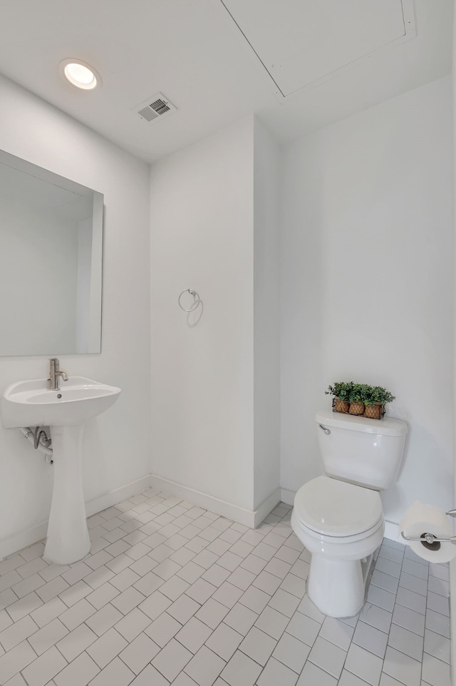 half bathroom with visible vents, tile patterned floors, baseboards, and toilet