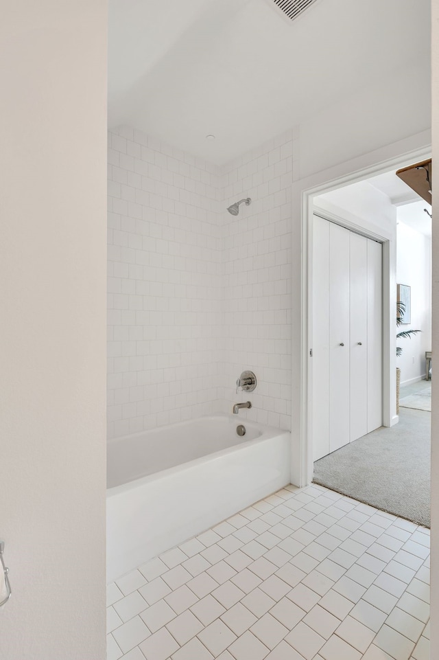 bathroom with tiled shower / bath and tile patterned flooring