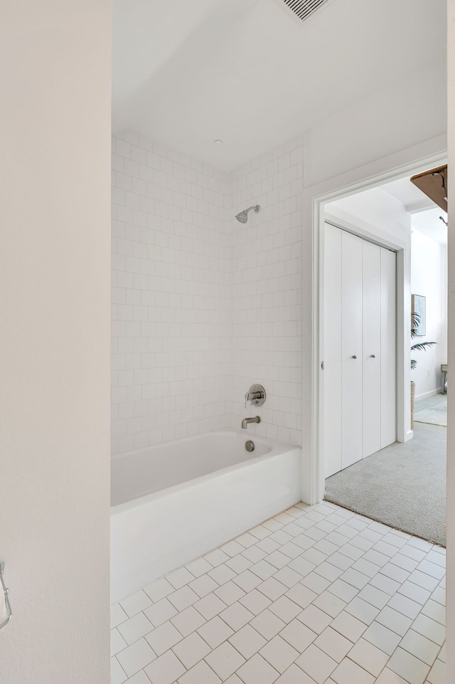 bathroom featuring tile patterned flooring and  shower combination