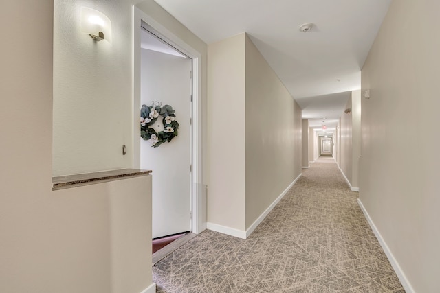 hallway with baseboards and carpet