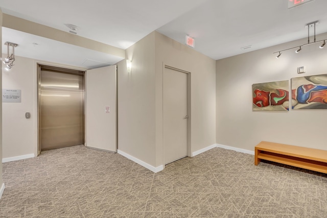 corridor with light colored carpet and elevator