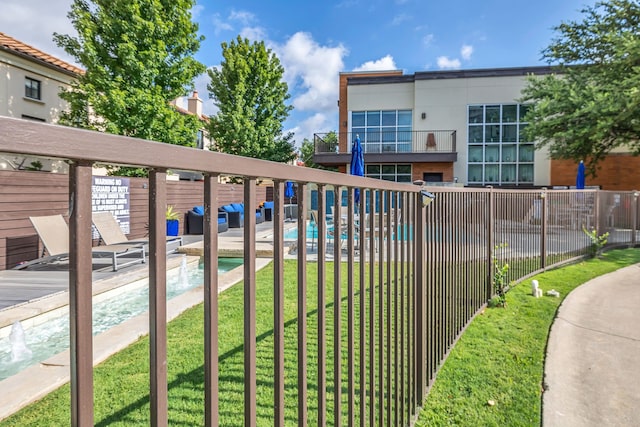 community pool with a yard and fence