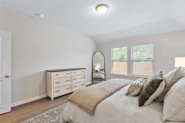 bedroom with hardwood / wood-style floors and vaulted ceiling