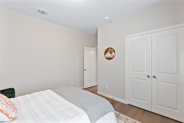 bedroom with dark hardwood / wood-style floors and a closet