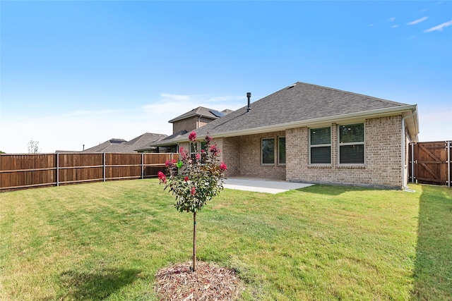 back of property with a lawn and a patio