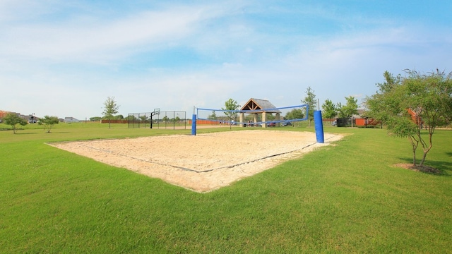 view of community with volleyball court and a yard