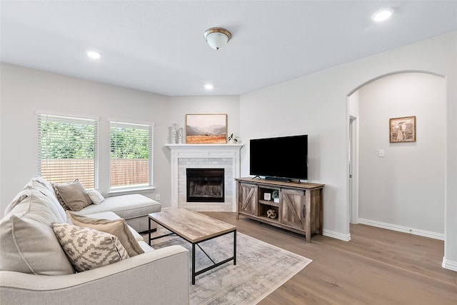 living room with hardwood / wood-style flooring and a tiled fireplace