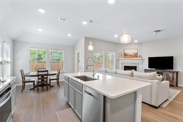 kitchen with stainless steel appliances, sink, pendant lighting, a center island with sink, and gray cabinets