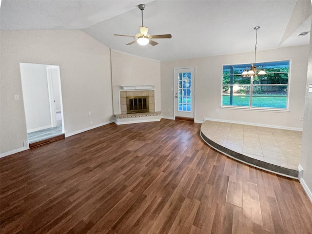 unfurnished living room with ceiling fan with notable chandelier, wood-type flooring, lofted ceiling, and a tiled fireplace