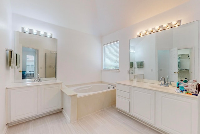 bathroom featuring tile patterned floors, vanity, and a bath