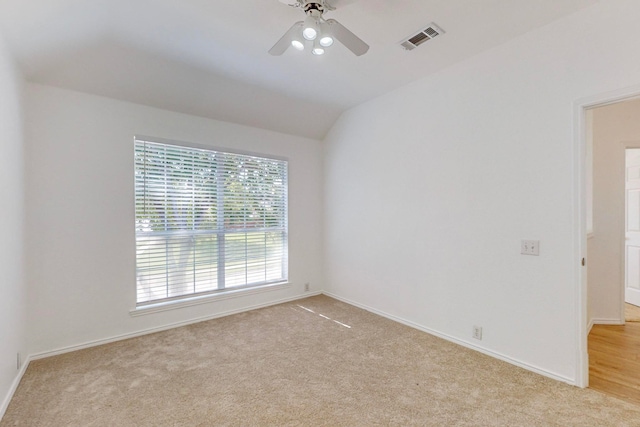 carpeted spare room featuring lofted ceiling and ceiling fan