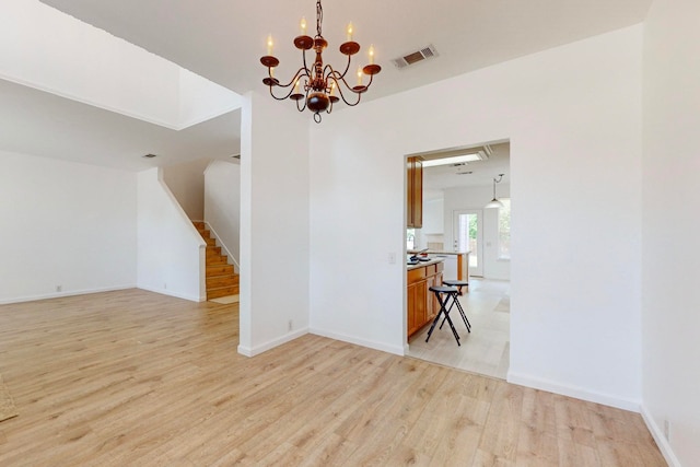 interior space with a notable chandelier and light wood-type flooring