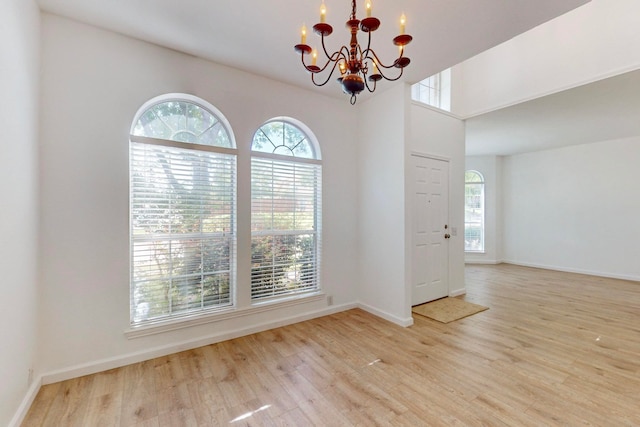 unfurnished room with light hardwood / wood-style flooring and an inviting chandelier