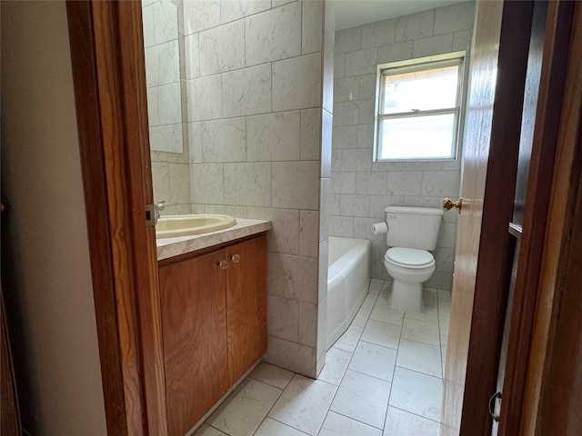 bathroom with vanity, toilet, tile walls, and tile patterned flooring