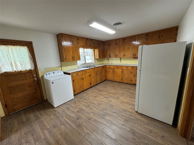 kitchen featuring light hardwood / wood-style flooring, washer / dryer, and white refrigerator