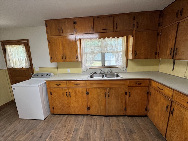 kitchen featuring washer / dryer, hardwood / wood-style floors, and sink