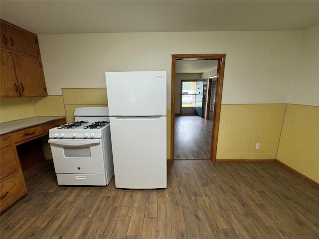 kitchen featuring white appliances and dark hardwood / wood-style flooring