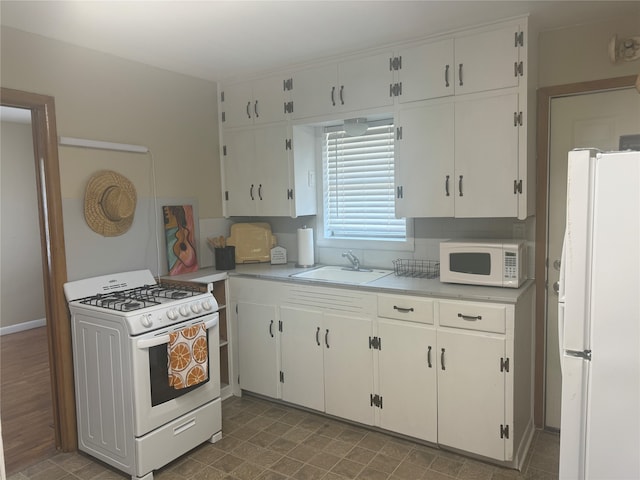 kitchen featuring white appliances, dark hardwood / wood-style flooring, backsplash, sink, and white cabinets