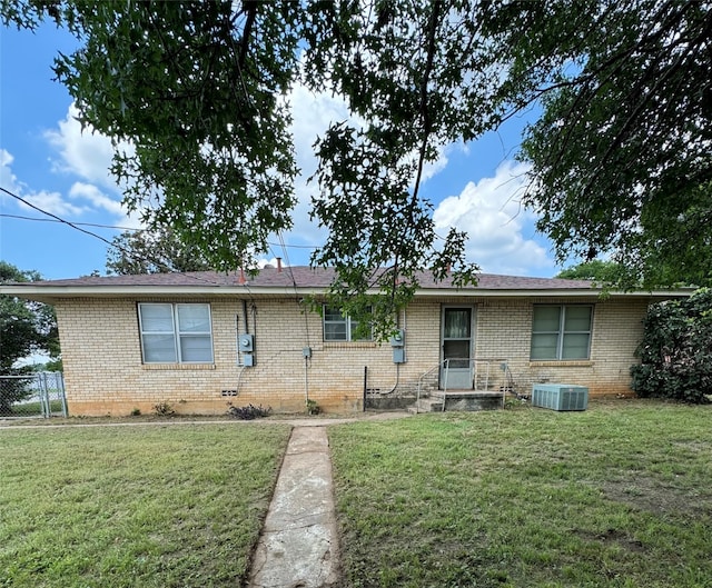 ranch-style home featuring central AC and a front yard