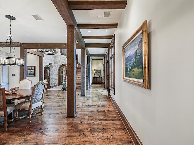 hall with beam ceiling, an inviting chandelier, and dark wood-type flooring