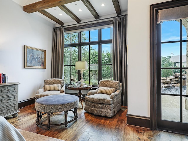 sitting room with hardwood / wood-style flooring, a healthy amount of sunlight, and beamed ceiling