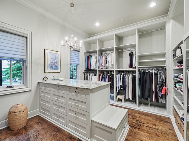 walk in closet featuring a chandelier and dark hardwood / wood-style floors