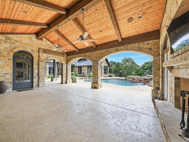 view of patio / terrace with an outdoor stone fireplace and ceiling fan