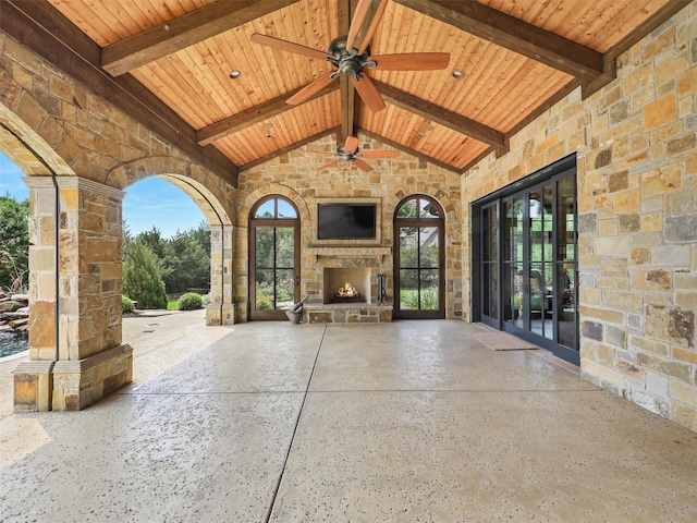 view of patio with an outdoor stone fireplace, french doors, and ceiling fan