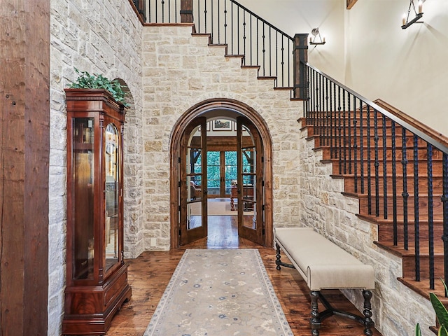 foyer with a towering ceiling, french doors, and dark hardwood / wood-style flooring