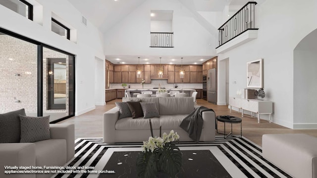 living room with a towering ceiling and light hardwood / wood-style flooring