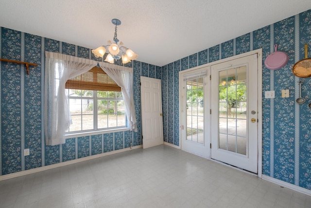 tiled spare room with a chandelier and a textured ceiling