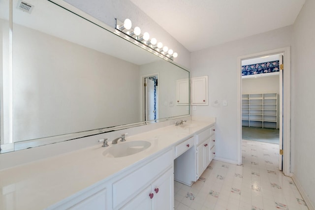 bathroom featuring tile flooring, double sink, and vanity with extensive cabinet space