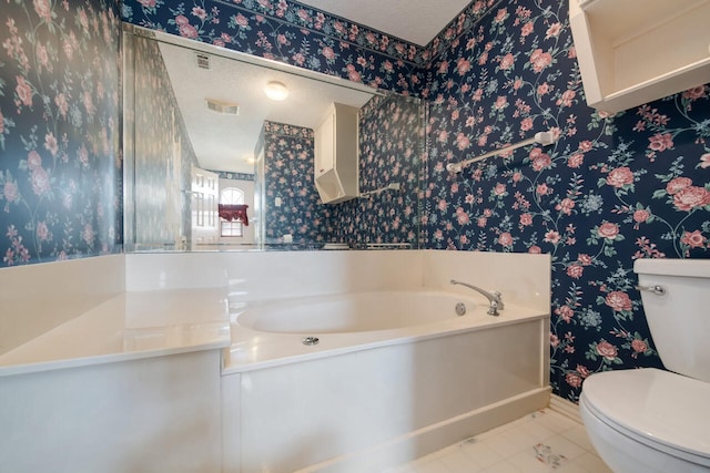 bathroom with tile flooring, vanity, toilet, and a textured ceiling