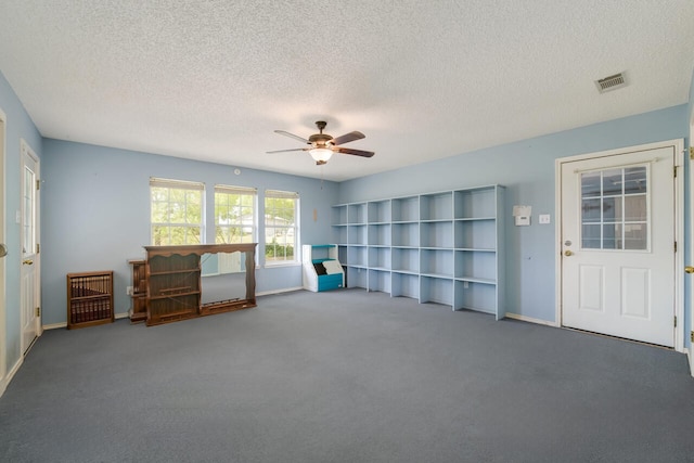 interior space featuring carpet flooring, ceiling fan, and a textured ceiling