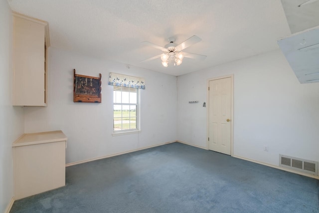 spare room with dark colored carpet and ceiling fan