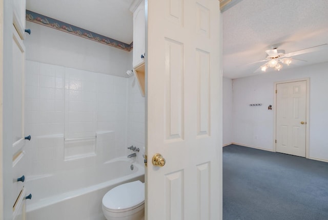 bathroom with ceiling fan, a textured ceiling, toilet, and tub / shower combination