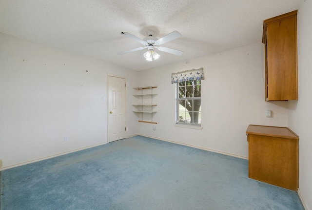 spare room featuring ceiling fan, carpet floors, and a textured ceiling